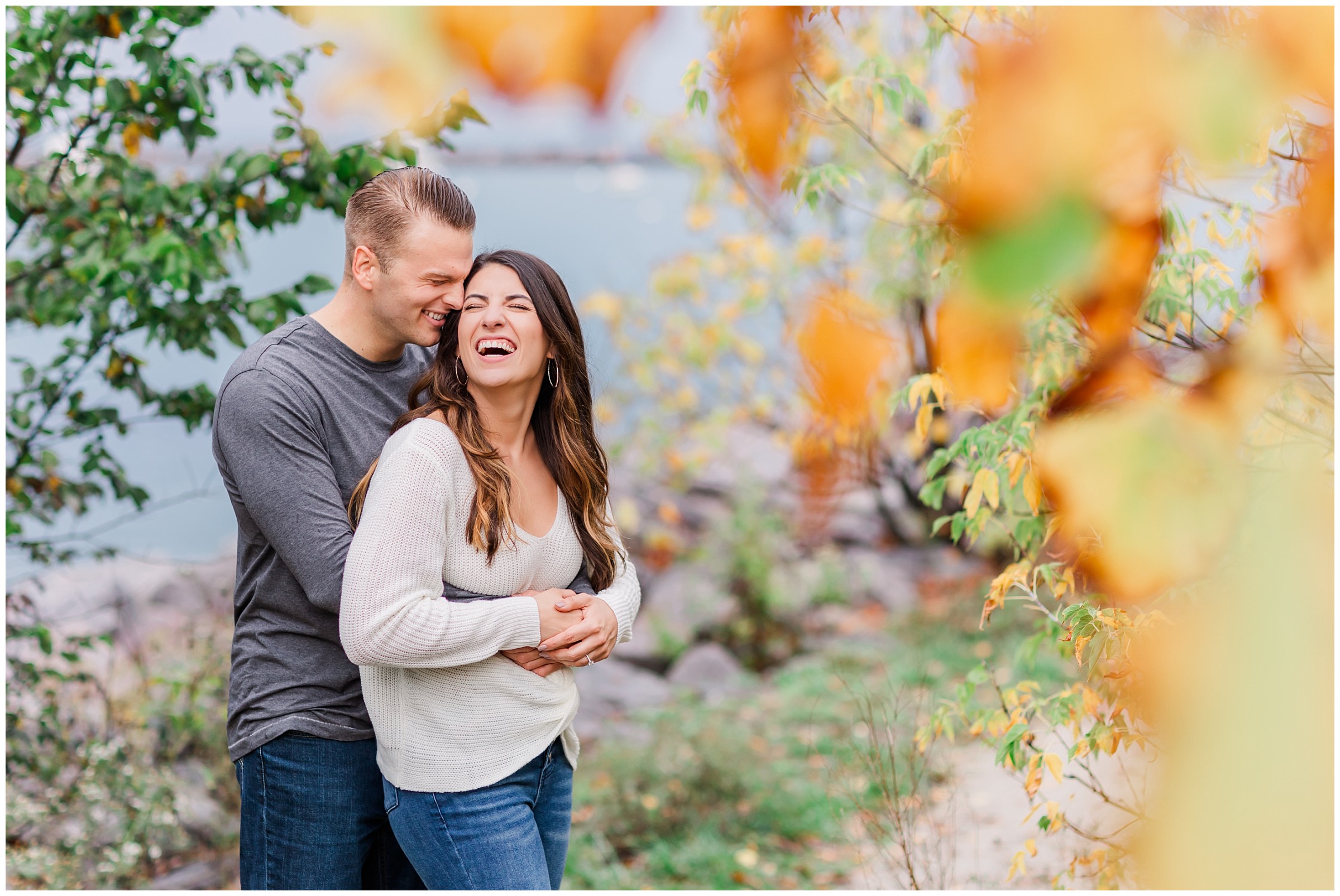 Couple laughing next to Lake Michigan on a rainy fall day