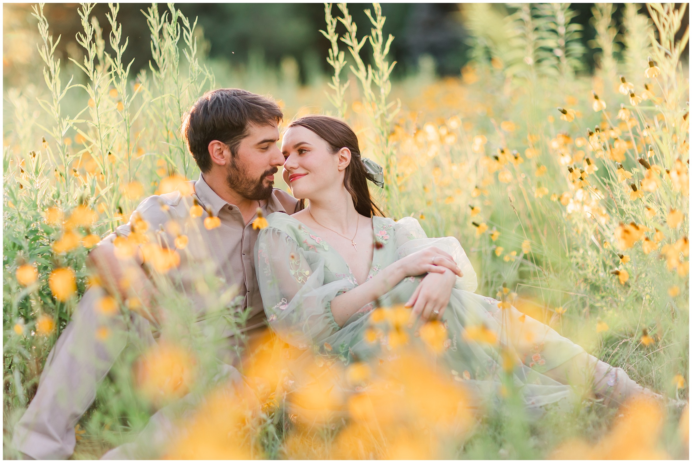 Man and woman sitting in a field of yellow wildflowers